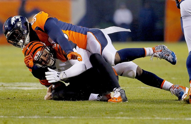 Cincinnati Bengals quarterback AJ Mc Carron his hit as he slides by Denver Broncos linebacker Shane Ray during the first half of an NFL football game Monday Dec. 28 2015 in Denver