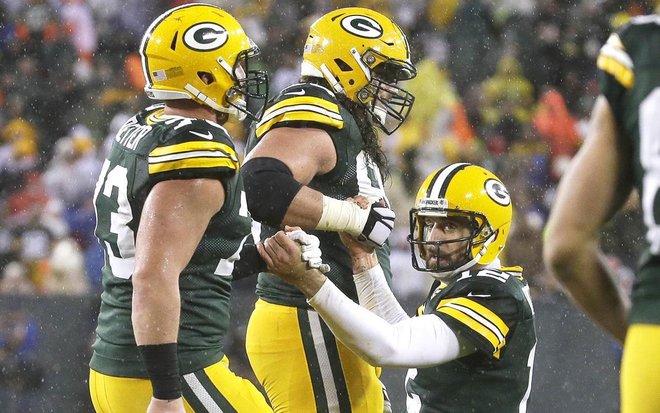 Packers quarterback Aaron Rodgers is helped up by center JC Tretter and tackle David Bakhtiari after an incomplete pass on fourth down near the end of the game Thursday. Green Bay’s offense has been struggling for several games