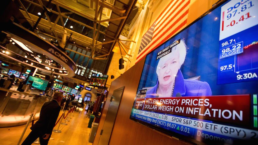 Traders work as Janet Yellen chair of the U.S. Federal Reserve is seen speaking on a television screen on the floor of the New York Stock Exchange in New York U.S. on Wednesday Dec. 16 2015. The Federal Reserve raised interest rates for the