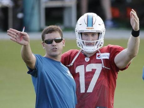 Miami Dolphins quarterback Ryan Tannehill talks with offensive coordinator Bill Lazor during an NFL football training camp practice Tuesday Aug. 11 2015 in Davie Fla