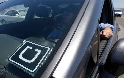 Uber driver Karim Amrani sits in his car parked near the San Francisco International Airport parking area in San Francisco Wednesday