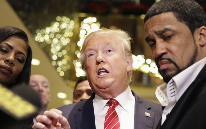 Republican Presidential candidate Donald Trump center talks with reporters while surrounded by a group of African American religious leaders in New York on Monday after a meeting with a coalition of 100 African American evangelical pastors and religious