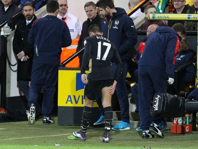 Arsenal's Chilean striker Alexis Sanchez limps off the pitch holding his leg during the English Premier League football match between Norwich City and Arsenal