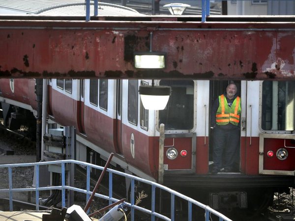 A worker stands at an entrance to a passenger train as it rests on tracks Thursday Dec. 10 2015 in Boston. The six-car train with passengers on board left a suburban Boston transit station without a driver Thursday and went through four stations withou