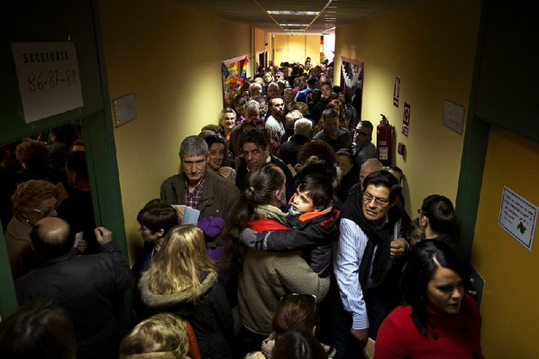 EMILIO MORENATTI						Credit AP				Voters line up in a crowded corridor at a polling station in Madrid during national elections Sunday