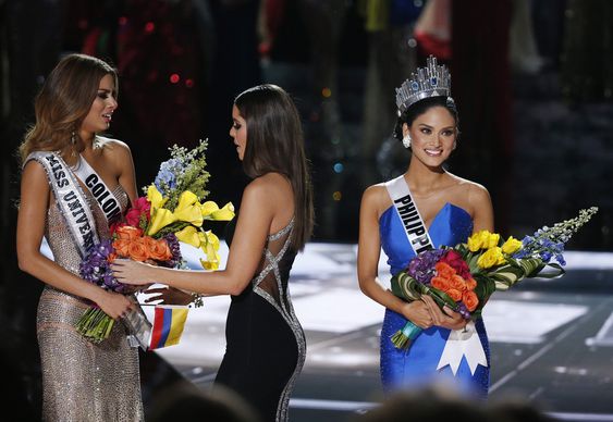 Paulina Vega center takes away the flowers and sash from Miss Colombia Ariadna Gutierrez left before giving it to Miss Philippines Pia Alonzo Wurtzbach right at the Miss Universe pageant Sunday Dec. 20 2015 in Las Vega