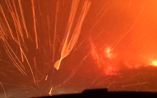 Embers fly past as the family drives through the fires