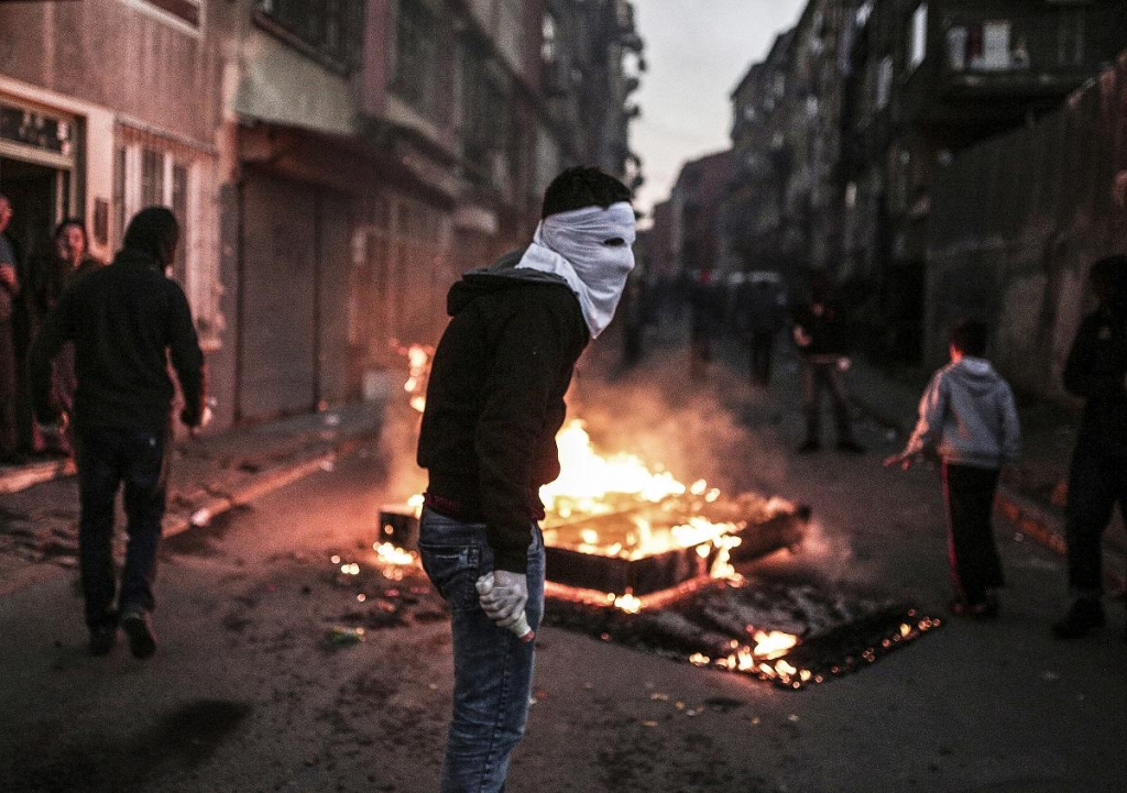 A masked protester holds a petrol bomb during clashes with Turkish police using water cannons and tear gas to disperse a demonstration in Istanbul protesting security operations against Kurdish rebels in southeastern Turkey