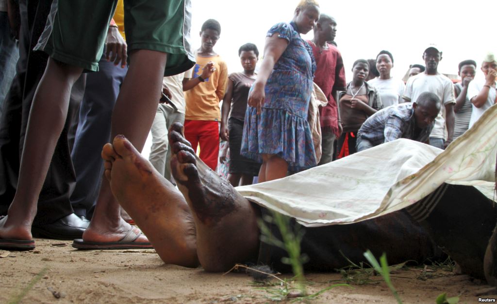 FILE- Residents look at the slain bodies of people killed at the Cibitoke district in Burundi's capital Bujumbura