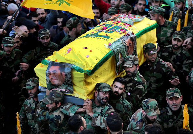 Hezbollah fighters center carry the coffin of Hezbollah high-profile militant Samir Kantar during his funeral procession in the southern suburb of Beirut Lebanon Monday Dec. 21 2015. Thousands of people have gathered for the funeral of Kantar who