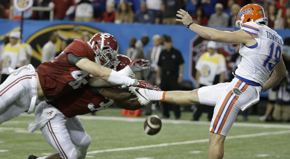 Alabama linebacker Keith Holcombe and Alabama linebacker Christian Miller block the punt of Florida punter Johnny Townsend during the first half of the Southeastern Conference championship NCAA college football game Saturday Dec. 5 2015