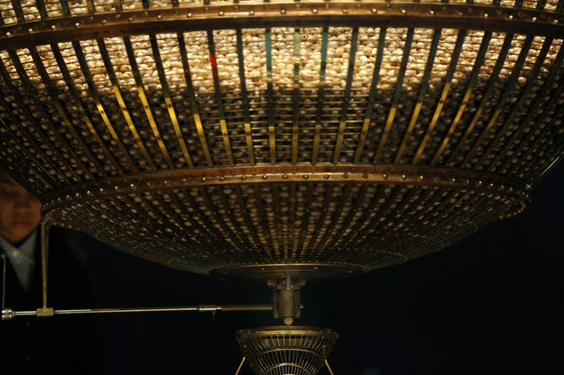 A ball bearing a ticket number falls from a giant drum during Spain's Christmas lottery draw in Madrid Tuesday Dec. 22 2015. Celebrations were guaranteed