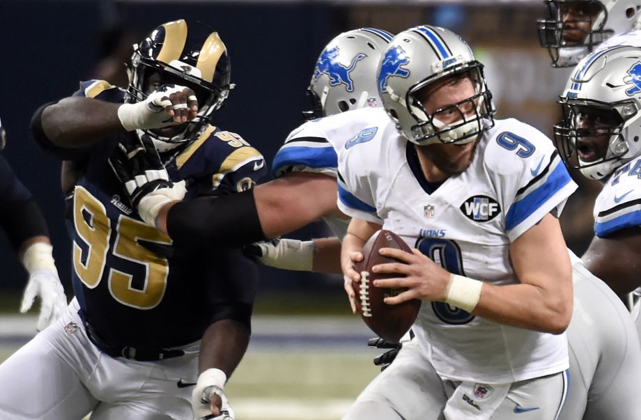 Detroit Lions quarterback Matthew Stafford right scrambles under pressure from St. Louis Rams defensive end William Hayes during the fourth quarter of an NFL football game Sunday Dec. 13 2015 in St. Louis