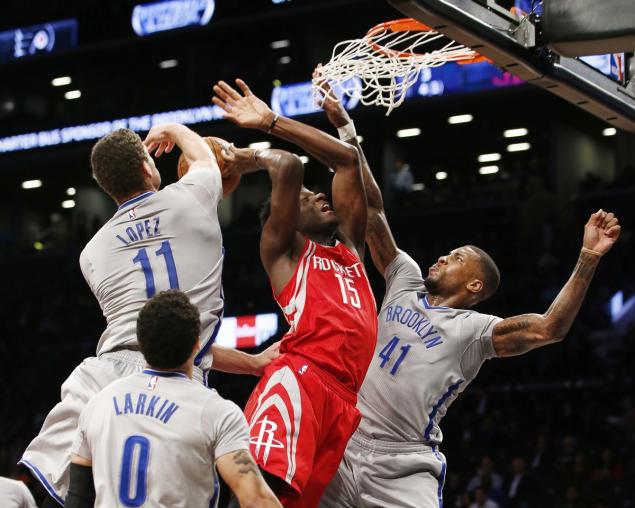 Brooklyn Nets center Brook Lopez and Nets forward Thomas Robinson knock the ball from Houston Rockets center Clint Capela in the first half of an NBA basketball game Tuesday Dec. 8 2015 in New York