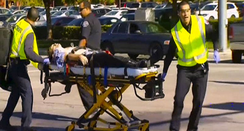 Rescue crews tend to the injured in the intersection outside the Inland Regional Center in San Bernardino California in this still image taken from video