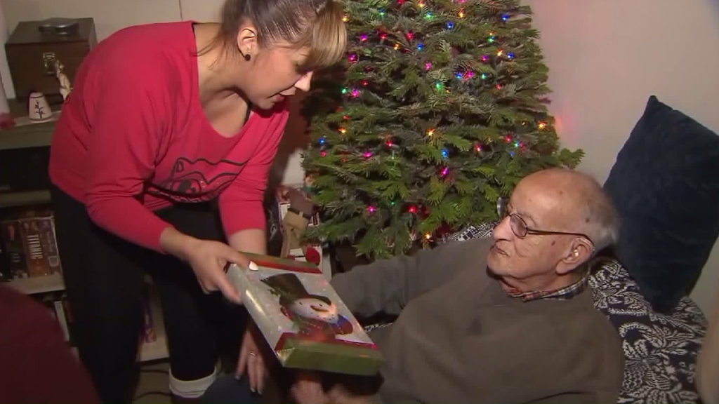 Herman Perry a Venice resident and World War II veteran opens presents on Dec. 21 2015 that were donated by LAPD officers