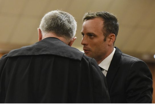 Oscar Pistorius talks to his defence lawyer ahead of his bail hearing in Pretoria South Africa Tuesday