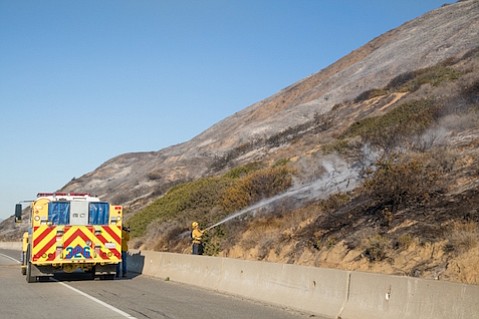 Firefighter putting out a hot spot along Highway 101 on Saturday December 26