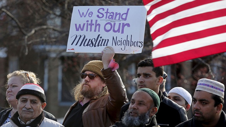 Frank Woodman holds a sign in support of his Muslim neighbors as he joins Bangladeshi and Yemeni Americans to protest against Islamic State and political and religious extremism during a rally in the Detroit suburb of Hamtramck Mich. on Dec. 11 2015