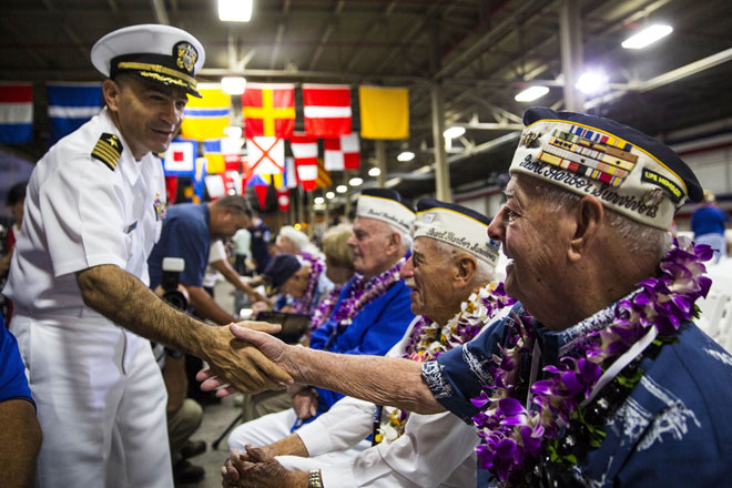 US Navy Captain Mark Manfredi greets USS Arizona Survivor Lou Conter before the start of a memorial service marking the 74th Anniversary of the attack on the US naval base at Pearl Harbor on the island of Oahu at the Kilo Pier at Joint Base Pearl