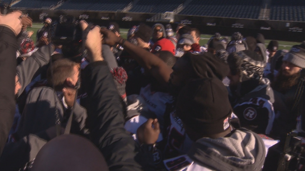 The Ottawa Red Blacks huddle at centre field at Investors Group Field after taking final walk through on Saturday