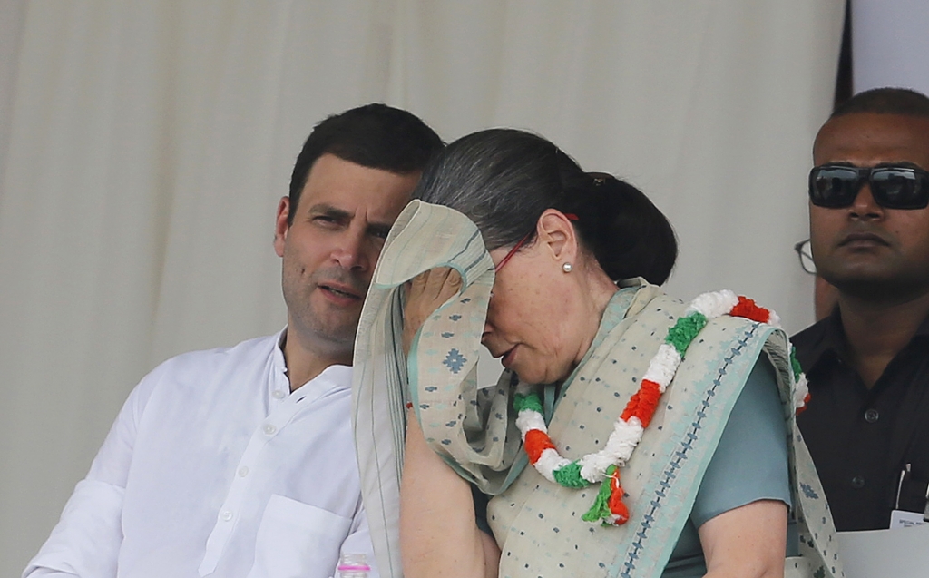 Indias Congress party president Sonia Gandhi wipes her sweat as partys vice-president Rahul Gandhi watches during a farmers rally at Ramlila ground in New Delhi India