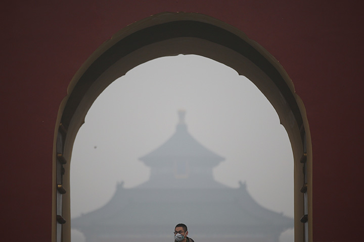 A man wearing mask visits Temple of Heaven Park during a day of heavy pollution