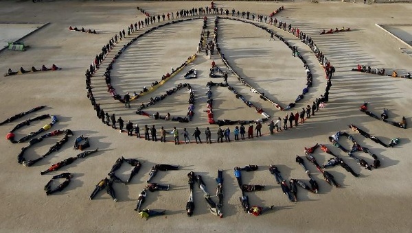 Hundreds of environmentalists arrange their bodies to call for renewable energy and peace at the base of the Eiffel Tower in Paris during COP21