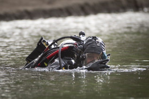 A member of the FBI dive team searches Seccombe Lake for evidence in connection with last week's fatal shooting at Inland Regional Center Friday Dec. 11 2