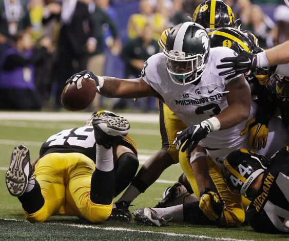 Michigan State's LJ Scott runs for a 1-yard touchdown during the second half of the Big Ten championship NCAA college football game against Iowa Saturday Dec. 5 2015 in Indianapolis