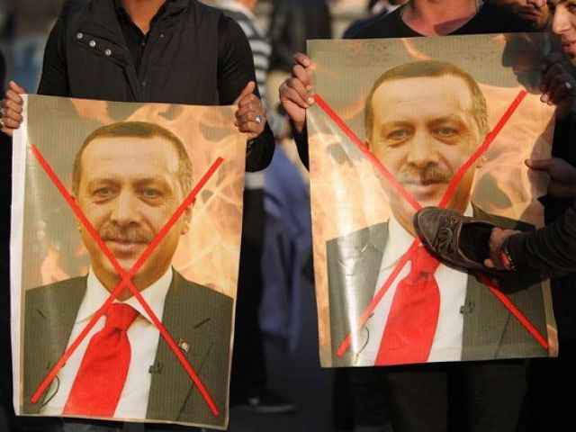 Iraqis hold crossed-out portraits of Turkey's President Erdogan during a demonstration gathering mainly members of Shia paramilitary forces in Baghdad's Tahrir Square