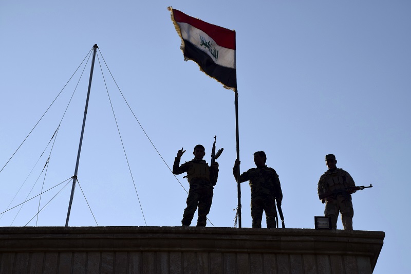 Iraqi soldiers plant the national flag over a government building in Ramadi as security forces advance their position in northern Ramadi 70 miles west of Baghdad Iraq. Iraqi forces on Tuesday reporte