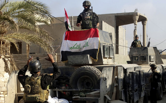 Iraqi security forces surround the government complex in central Ramadi 70 miles west of Baghdad Iraq Monday Dec. 28 2015. Iraqi military forces on Monday retook a strategic government complex in the city of Ramadi from Islamic State