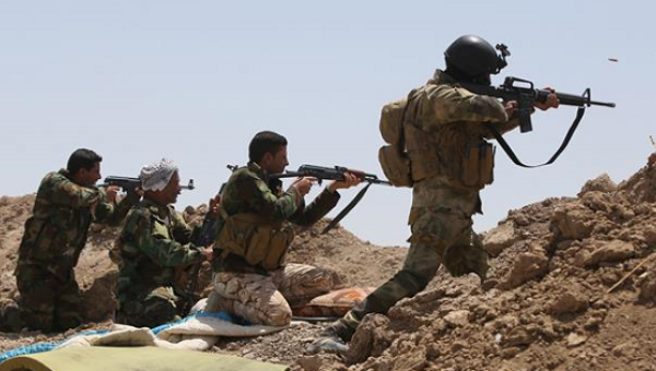 Iraqi soldiers and Shia volunteer fighters hold a post as they fire toward ISIL positions in the Garma district of Anbar Province west of the Iraqi capital Baghdad May. 19 2015