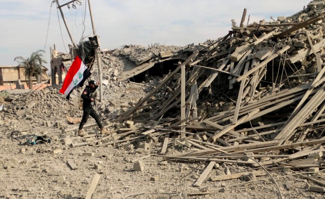 Iraqi soldier holds a national flag near the provincial council building in central Ramadi 70 miles west of Baghdad Iraq. Iraqi military forces on Monday retook a strategic government complex in