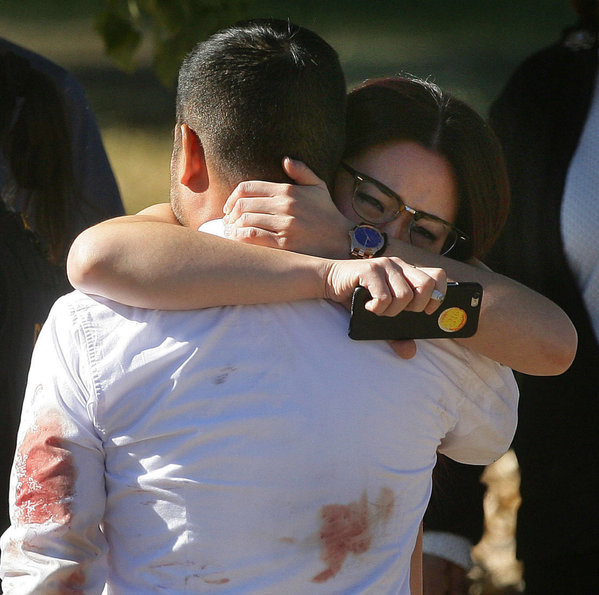 A couple embrace in the aftermath of the shooting in California. DAVID BAUMAN  The Press-Enterprise