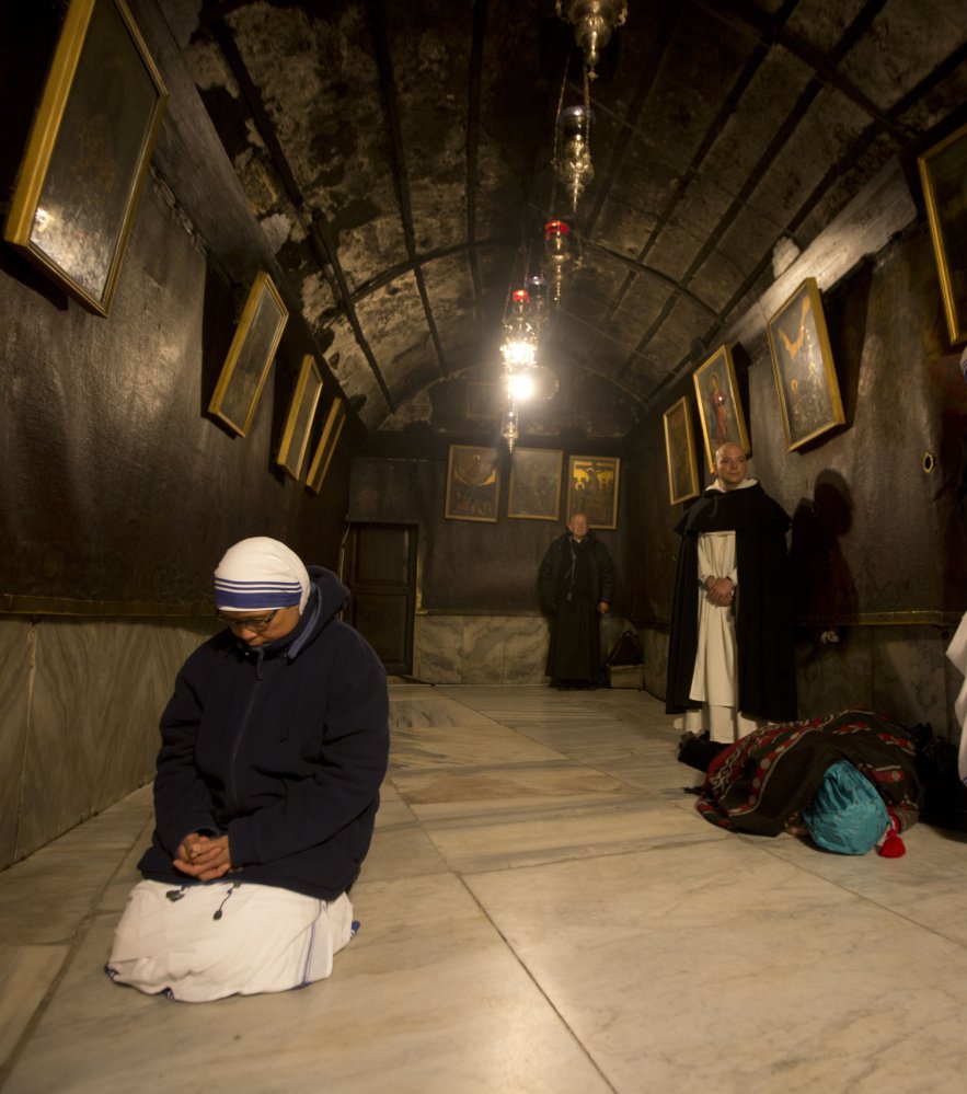 A nun prays inside the Grotto at the Church of the Nativity in Bethlehem. Months of Israeli Palestinian violence have cast a pall over Christmas celebrations