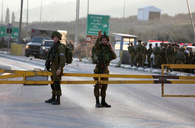 Israeli security forces stand guard at the site of a car ramming attack at the Huwara checkpoint near the West Bank city of Nablus