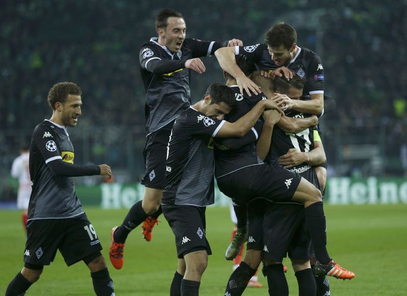 Borussia Moenchengladbach players celebrate the first goal against Sevilla during the UEFA Champions League group stage football match. – Reuters pic