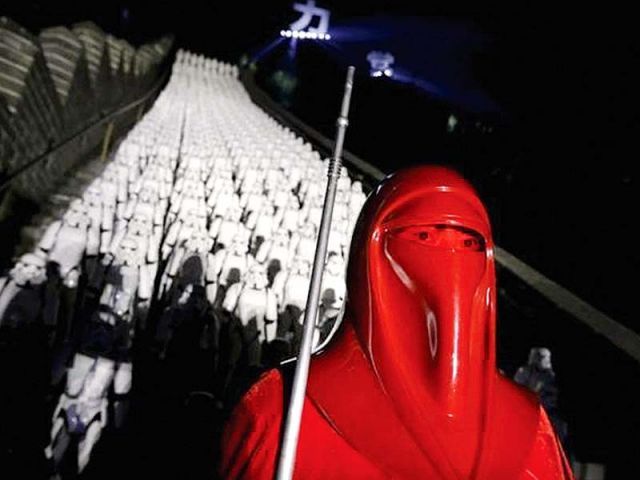 Fan dressed as Star Wars character poses in front of 500 replicas of the Stormtrooper characters during Star Wars The Force Awakens promotions