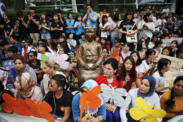 Demonstrators sit around a “comfort woman” statue during the weekly Wednesday protest demanding an apology and compensation from the Japanese government in Seoul South Korea