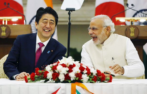 Japan's Prime Minister Shinzo Abe and his Indian counterpart Narendra Modi shares a moment during a signing of agreement at Hyderabad House in New Delhi on December 12