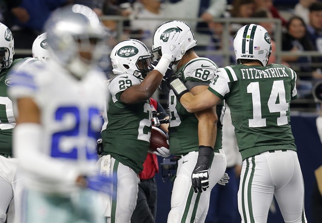 Dallas Cowboys Deji Olatoye walks away as New York Jets Bilal Powell, Breno Giacomini and Ryan Fitzpatrick celebrate a touchdown scored on a run by Powell in the first half of an NFL football game Saturday Dec. 19 2015 in Arlingt