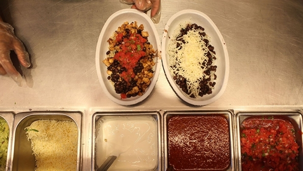 Cooks prepare food at Chipotle Mexican Grill