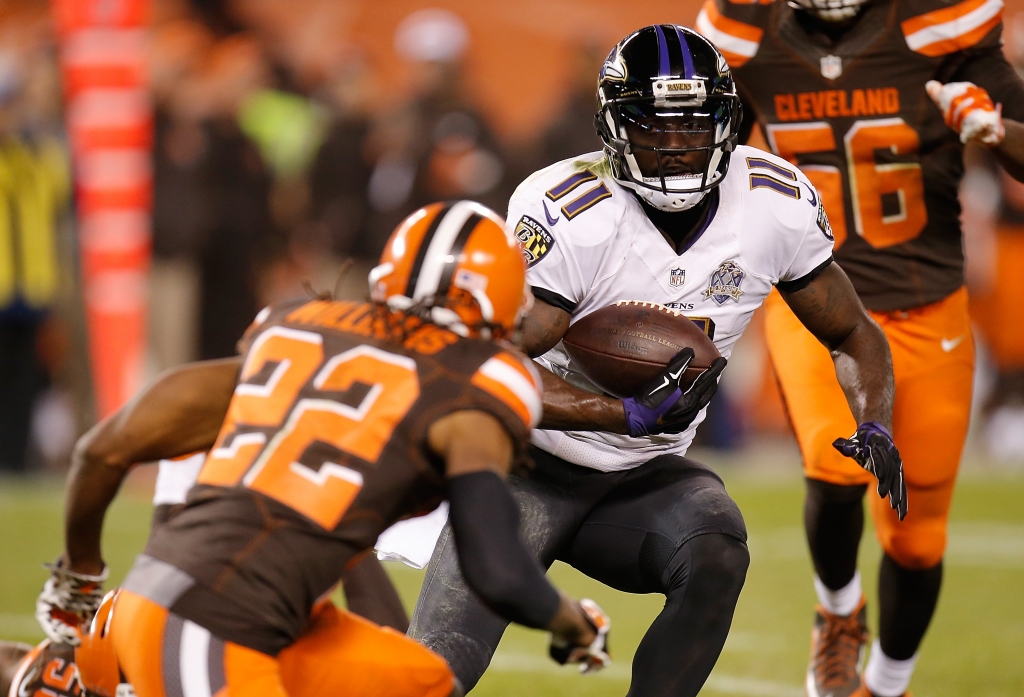 CLEVELAND OH- NOVEMBER 30 Kamar Aiken #11 of the Baltimore Ravens carries the ball in front of Tramon Williams #22 of the Cleveland Browns during the fourth quarter at First Energy Stadium