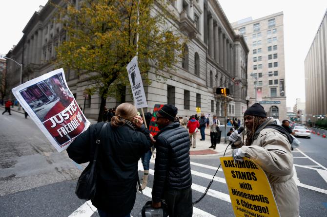 499271866-protestors-cross-a-street-in-front-of-the-courthouse