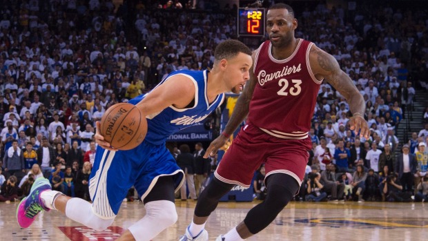 Warriors guard Stephen Curry dribbles the basketball against Cleveland Cavaliers forward Le Bron James