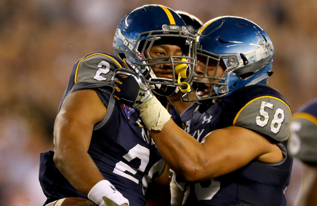 Daiquan Thomasson #26 of the Navy Midshipmen is congratulated by teammate Daniel Gonzales #58 after Thomasson intercepted a pass in the final minutes of the game against the Army Black Knights