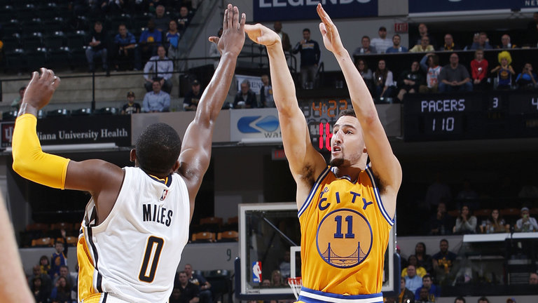 Klay Thompson of the Golden State Warriors shoots under pressure from C.J. Miles of the Indiana Pacers