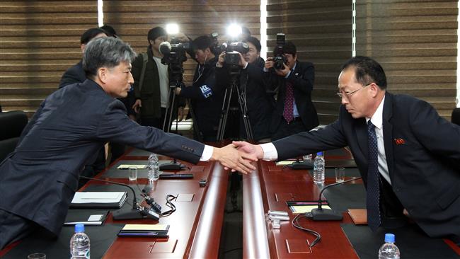 South Korean Vice Unification Minister Hwang Boo Gi, Seoul’s chief delegate for high-level talks with North Korea shakes hands with his North Korean counterpart Jon Jong Su during their meeting at the Kaesong joint industrial zone on the North